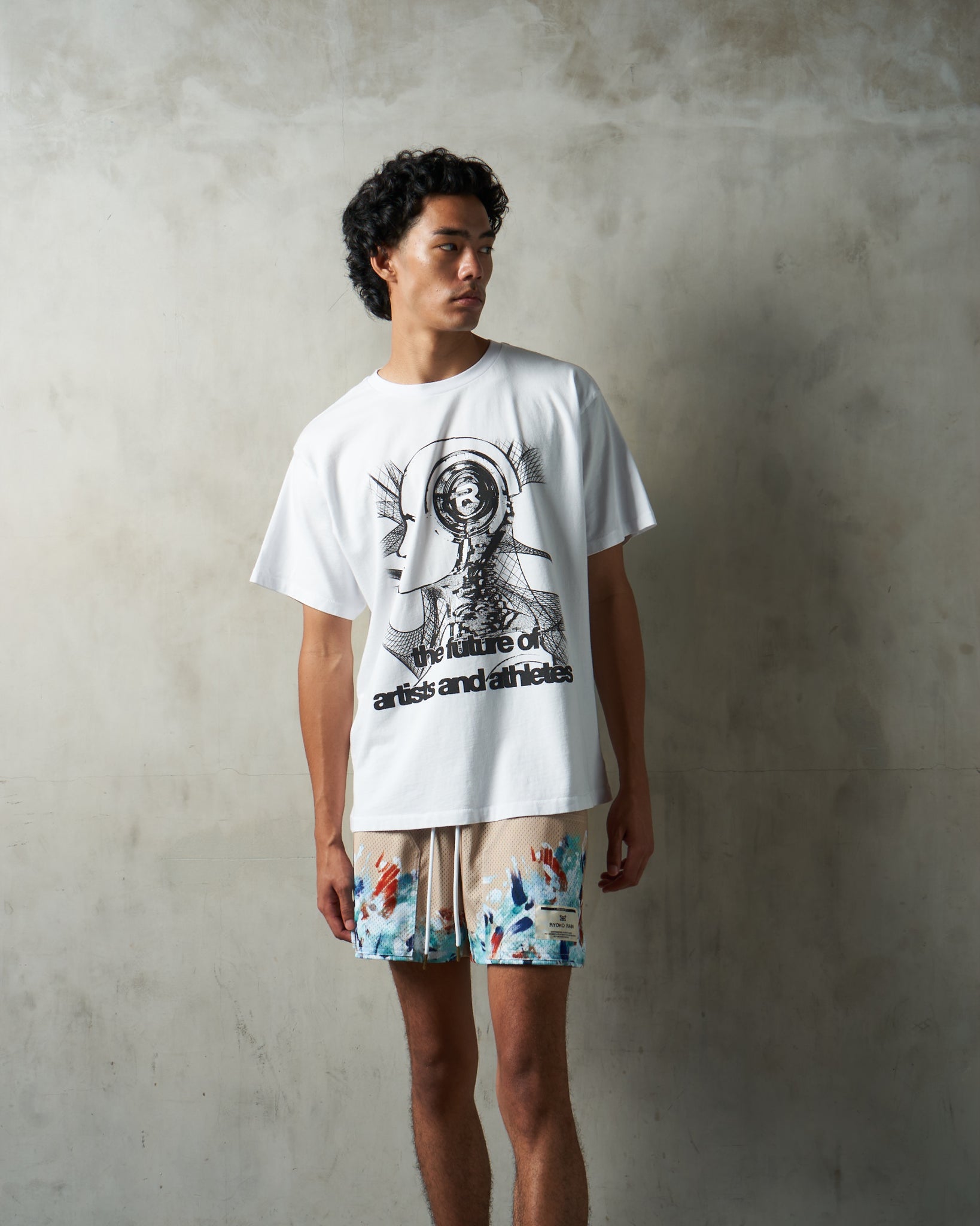 Model wearing the Ryoko Rain Artists and Athletes Collection. Model is wearing "The Future" white tee and Artist- tan shorts.