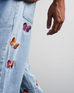 Side view of denim light blue washed butterfly embroidered jeans