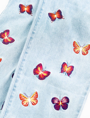 Ryoko Rain butterfly jeans. Small blue, red, and yellow butterflies embroidered on both legs